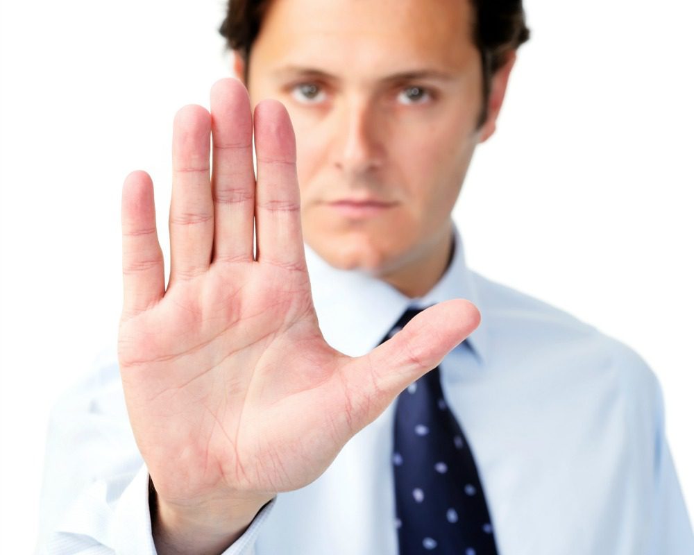 Businessman holding out his hand to show 'stop!'